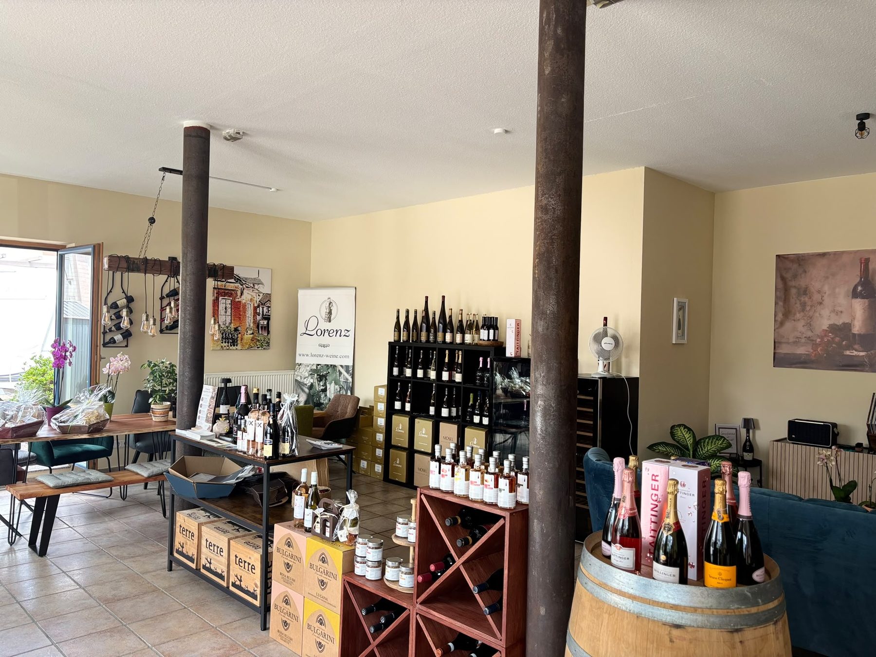 Blick in den Verkaufsraum von Weinglück mit Weinregalen, Holztischen und Sitzecke