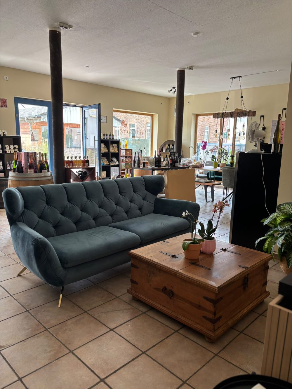 Sitzecke mit blauem Samtsofa und niedrigem Holztisch im Verkaufsraum