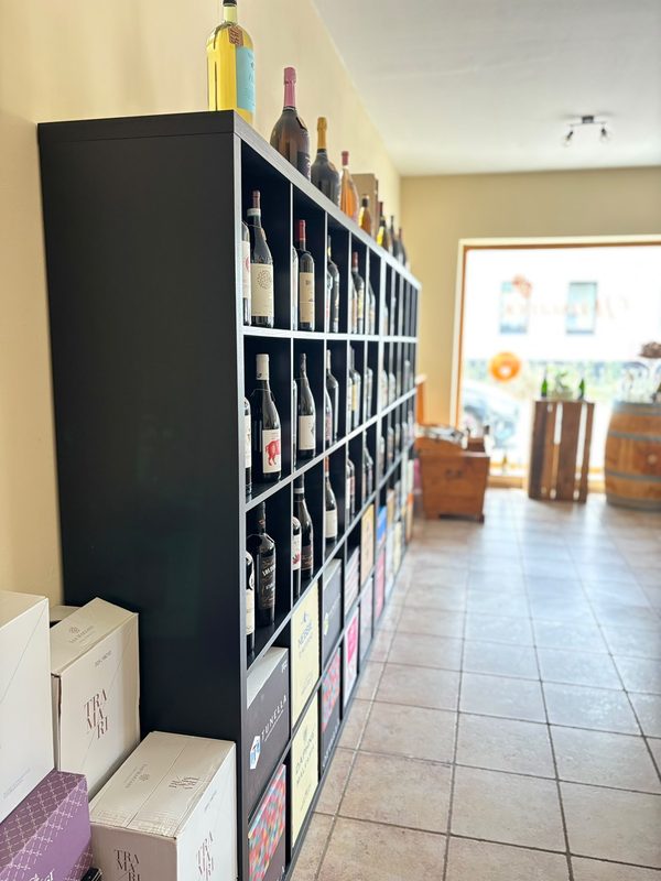 Regalwand mit Weinflaschen vor dem Schaufenster